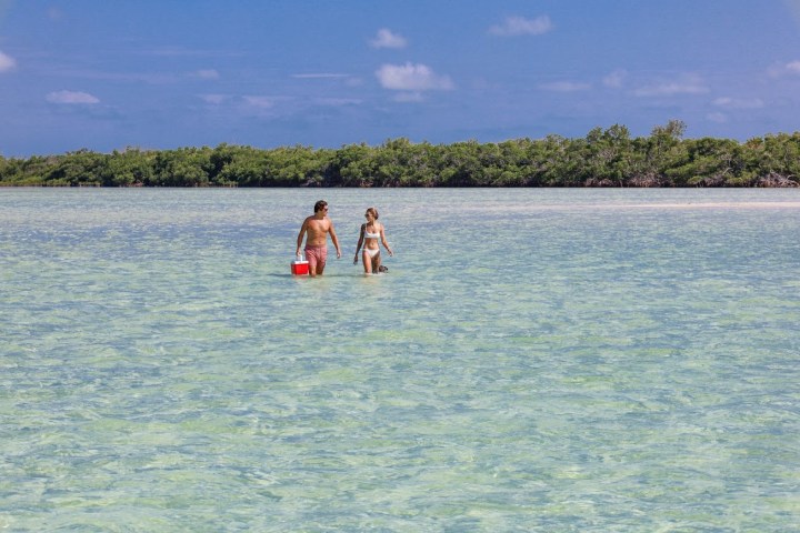 a couple walking on a secluded sandbar in the Florida Keys