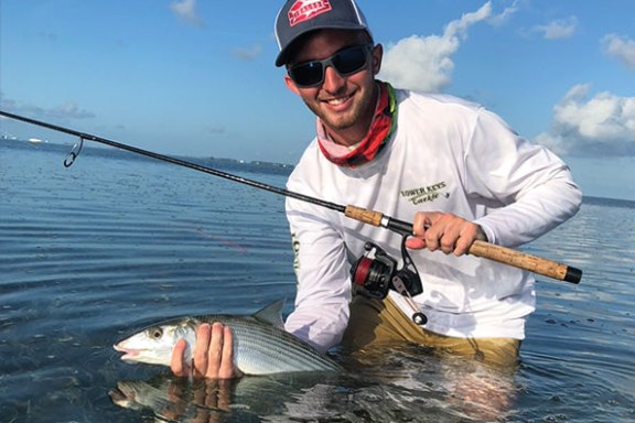 a man holding a fish on a boat in the water